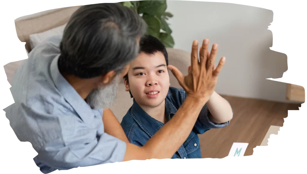Support worker high fiving disabled person