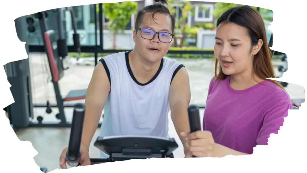 Support worker with disabled boy at gym