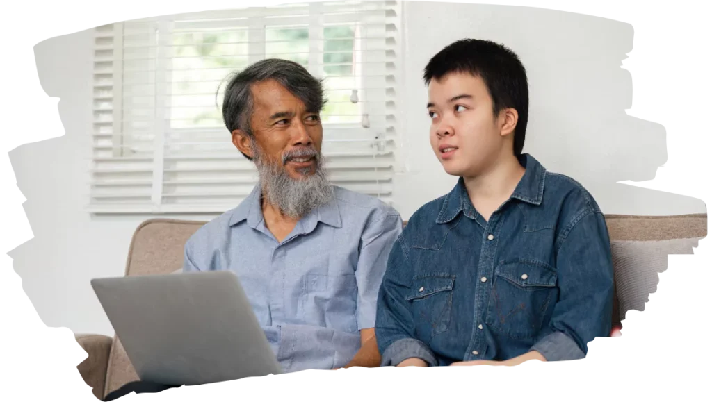 Support worker using laptop with disabled person