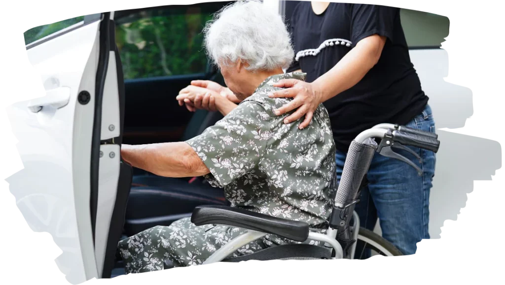 Support worker helping disabled woman into car